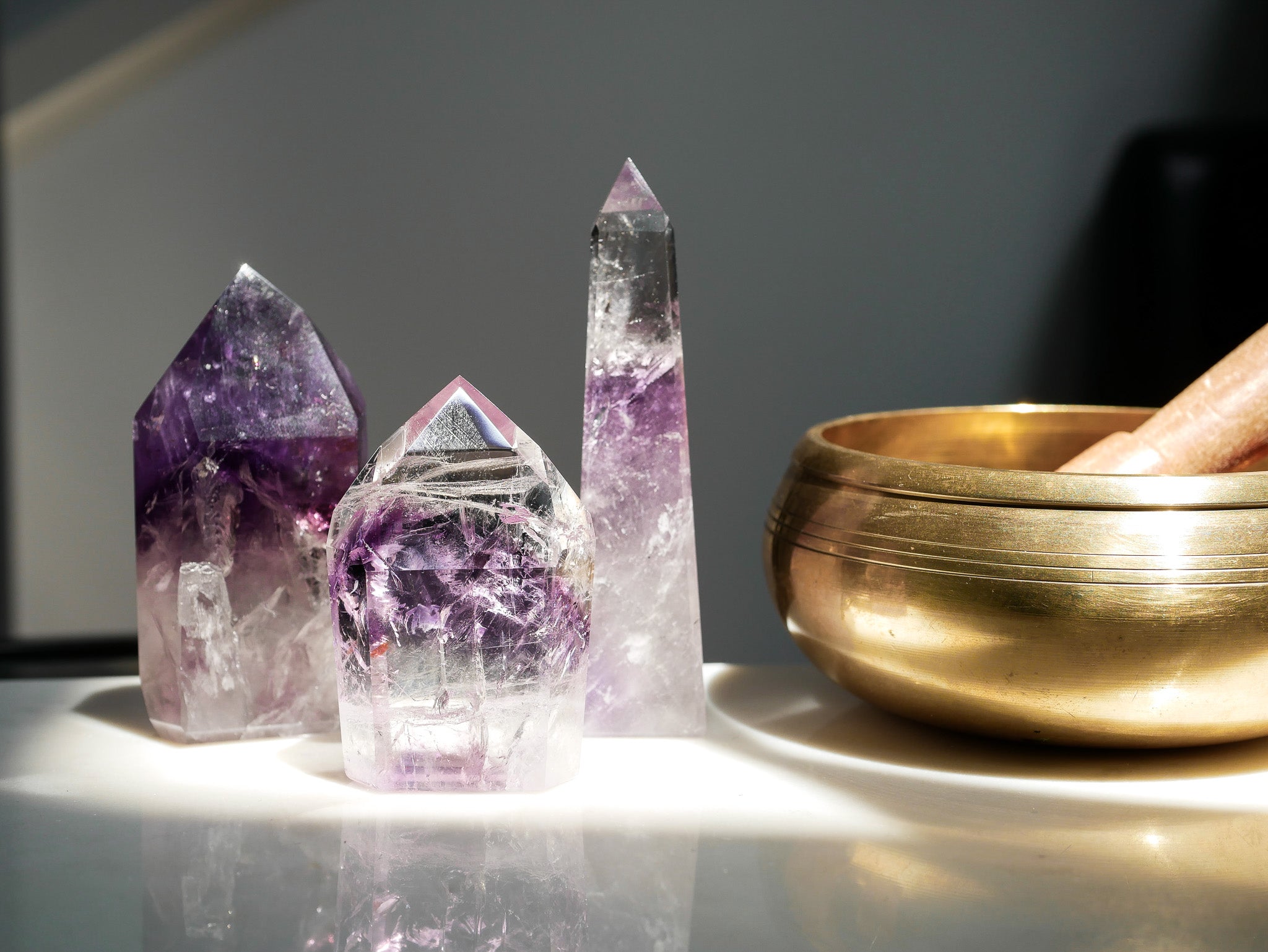 Crystal towers and a gold bowl on a reflective surface with a dark background