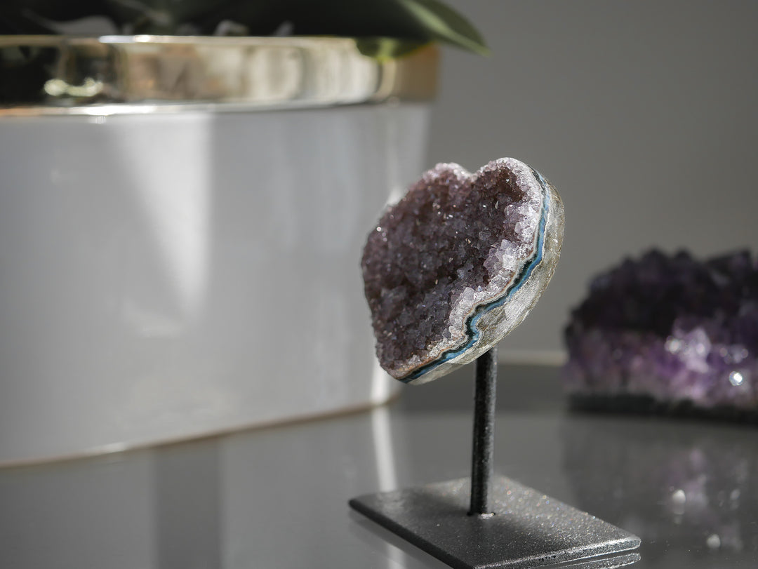 Amethyst crystal on a stand with a blurred background