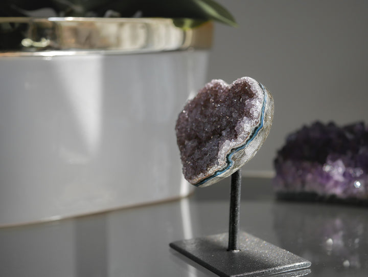 Amethyst crystal on a stand with a blurred background